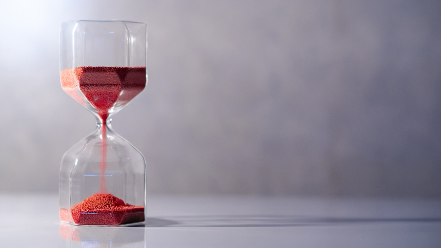 Red sand running in hourglass
